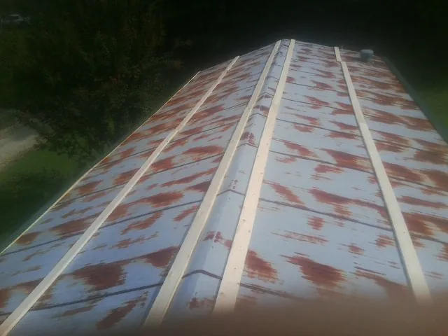 Rusted metal roof panels with new wood purlins before replacement — Storm Damage Roof Repair in Hooks by Roofing Brothers