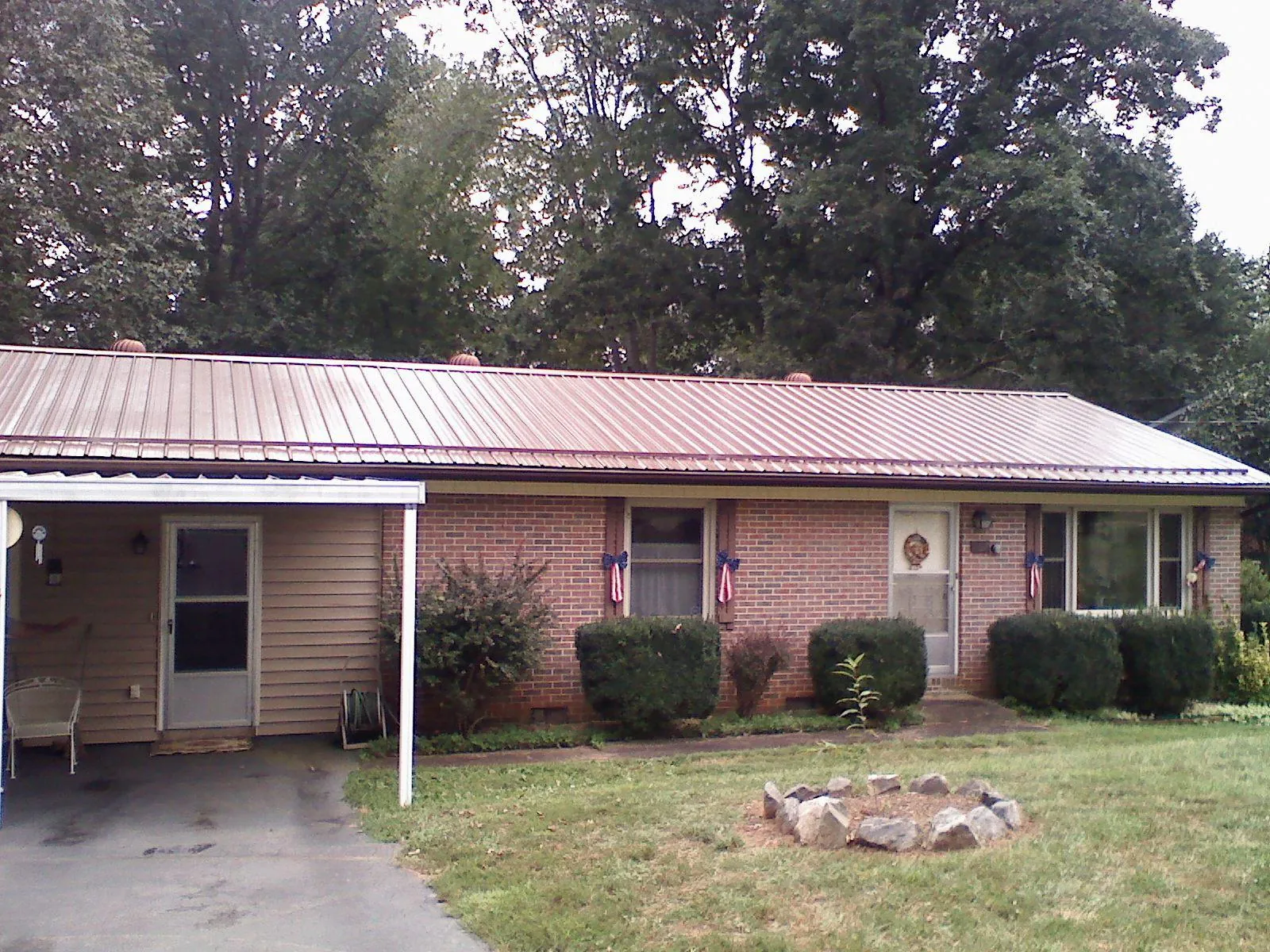 Bronze metal roof and carport on a brick ranch home — Roof Repair work by our crew in Hooks